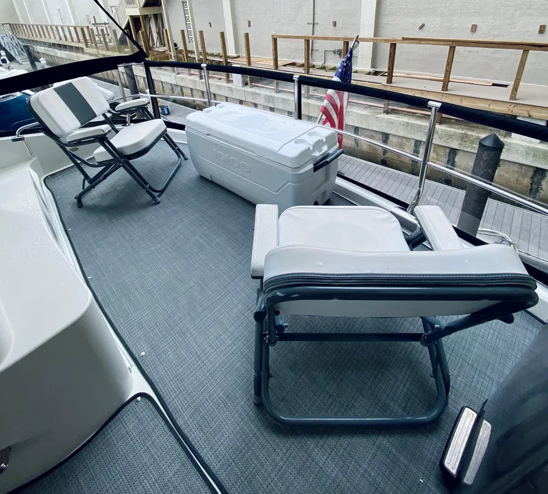 Slide: The Image of 2006 Marquis 59 yacht deck with chairs, cooler, and American flag. - 21