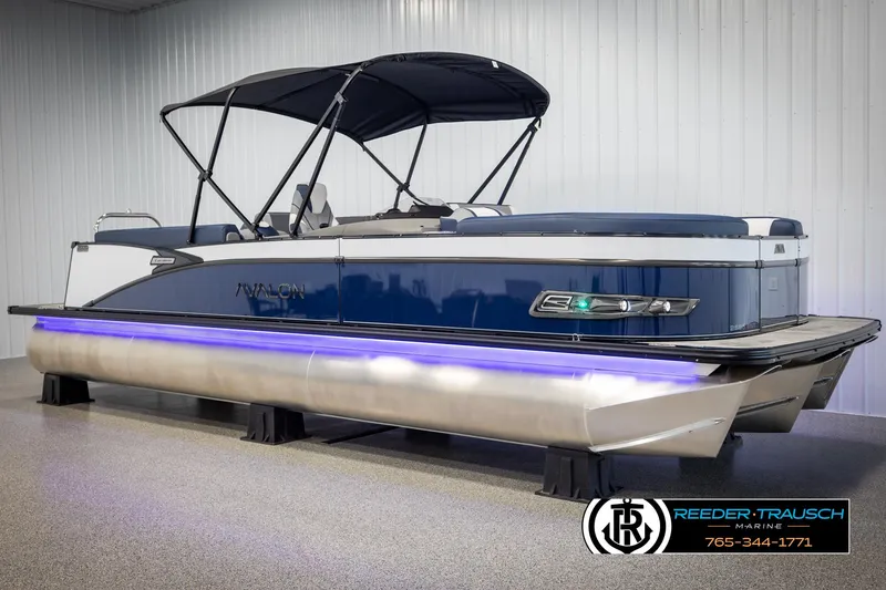 Slide: The Image of 2025 Avalon Catalina Entertainer pontoon boat with blue exterior and canopy in showroom. - 3