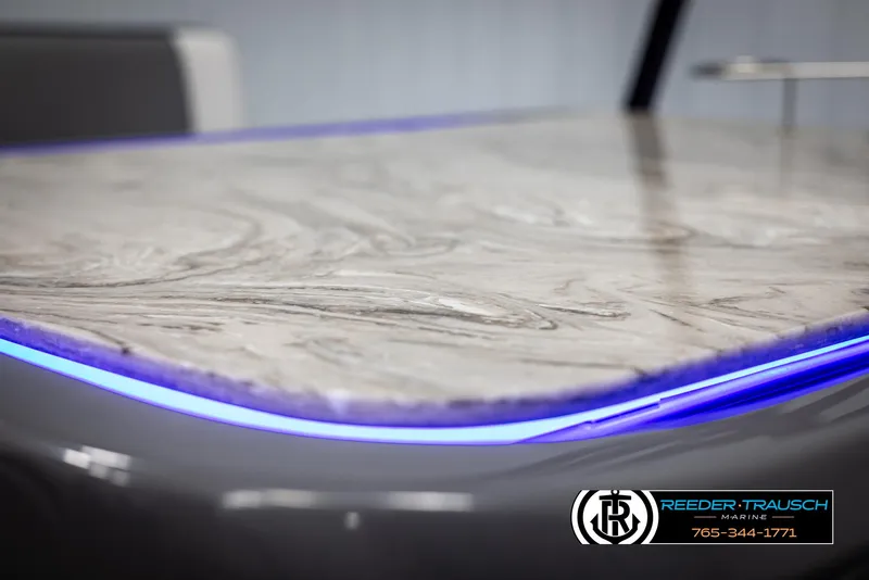 Slide: The Image of 2025 Avalon Catalina Entertainer table with blue LED lighting, Reeder-Trausch Marine logo. - 38
