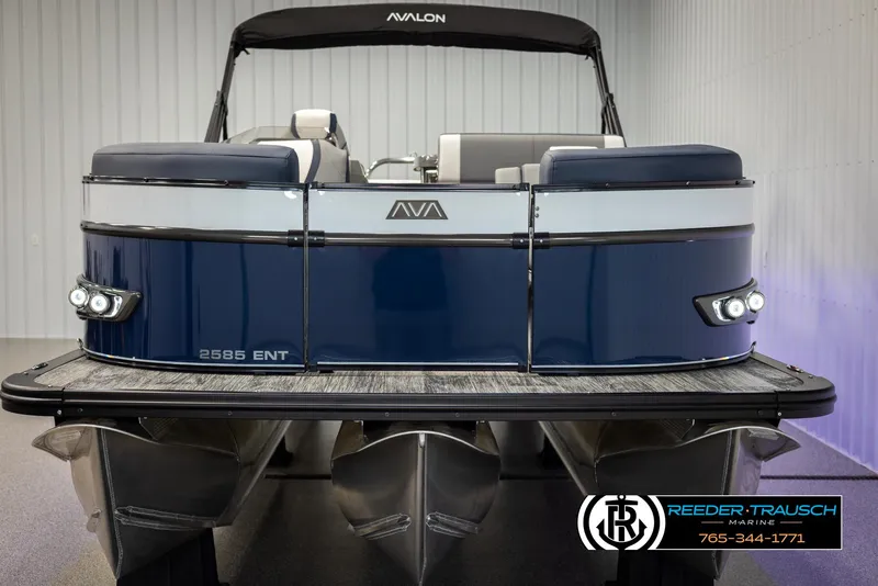 Slide: The Image of 2025 Avalon Catalina Entertainer pontoon boat, blue and white, displayed indoors. - 8