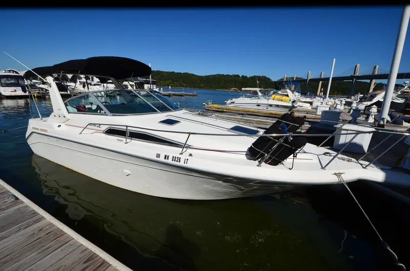 The Image of 1992 Sea Ray 290 Sundancer docked at a marina under clear blue skies. - 1