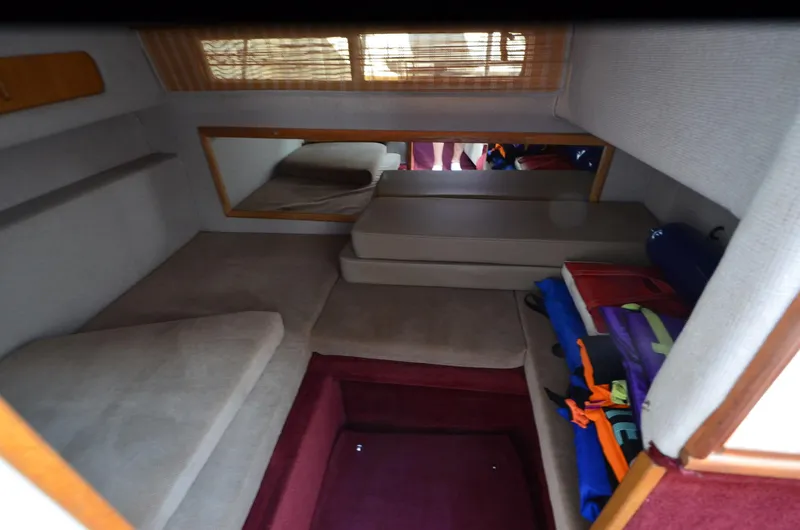 Slide: The Image of 1992 Sea Ray 290 Sundancer cabin interior with cushions and storage space. - 11