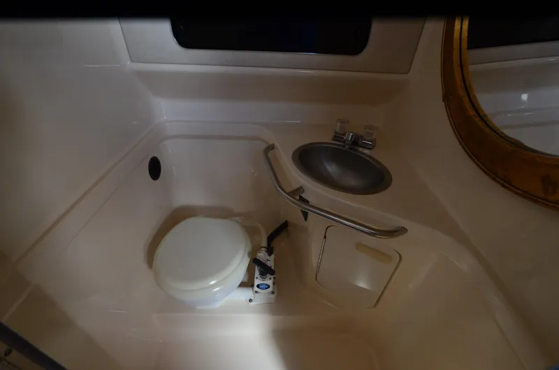 Slide: The Image of 1992 Sea Ray 290 Sundancer bathroom with toilet and sink. - 12