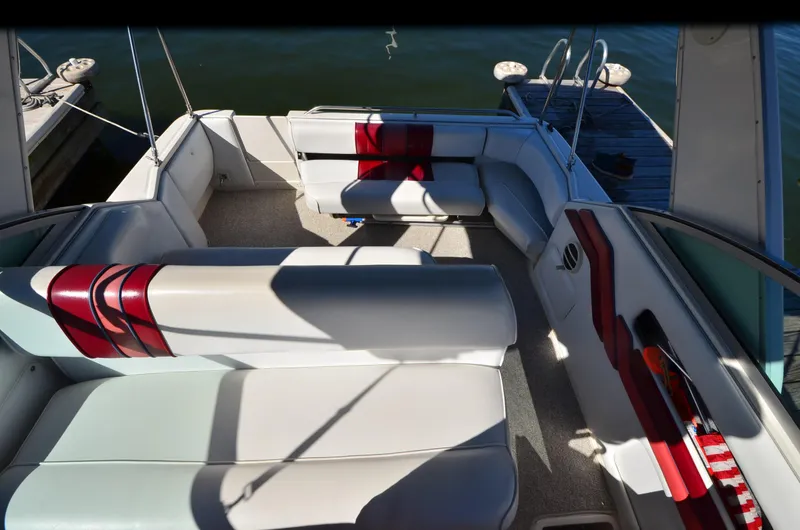 Slide: The Image of 1992 Sea Ray 290 Sundancer boat interior with white and red seating, docked by the water. - 15