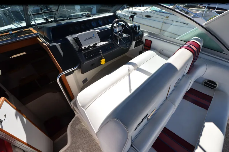Slide: The Image of 1992 Sea Ray 290 Sundancer boat interior with white seating and navigation equipment. - 18