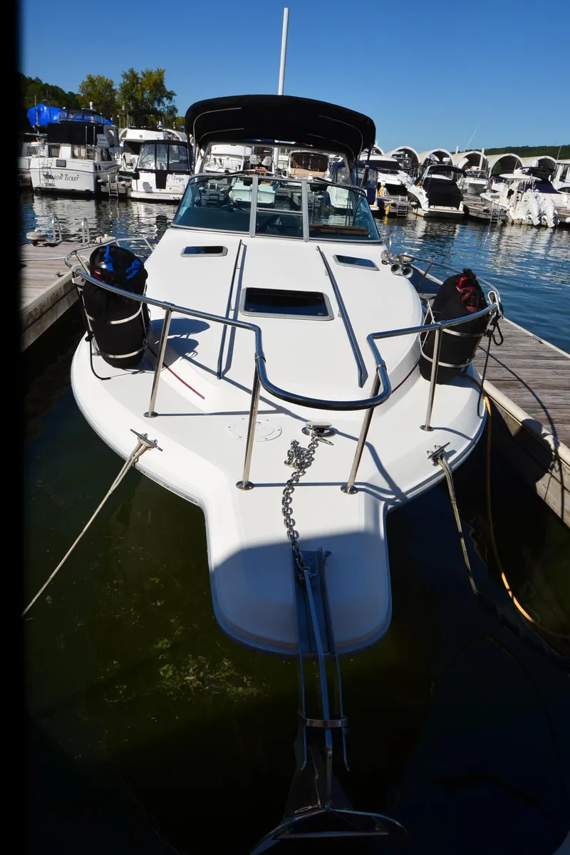 Slide: The Image of 1992 Sea Ray 290 Sundancer docked at a marina, surrounded by other boats. - 30