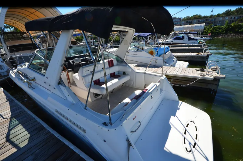 Slide: The Image of 1992 Sea Ray 290 Sundancer docked, featuring spacious seating and canopy. - 5