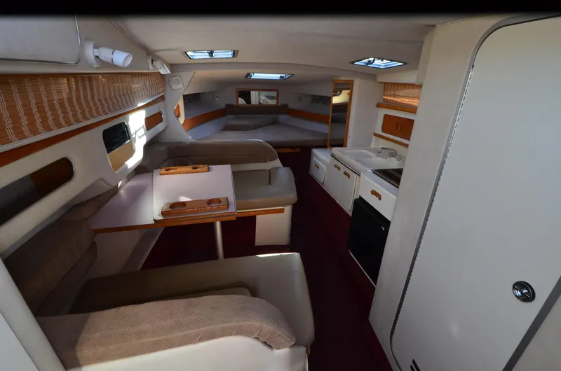 Slide: The Image of Interior of 1992 Sea Ray 290 Sundancer boat with seating, table, and kitchenette. - 6