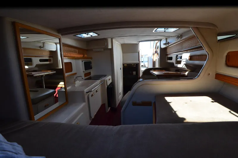 Slide: The Image of Interior of a 1992 Sea Ray 290 Sundancer boat, featuring a cozy cabin layout. - 8
