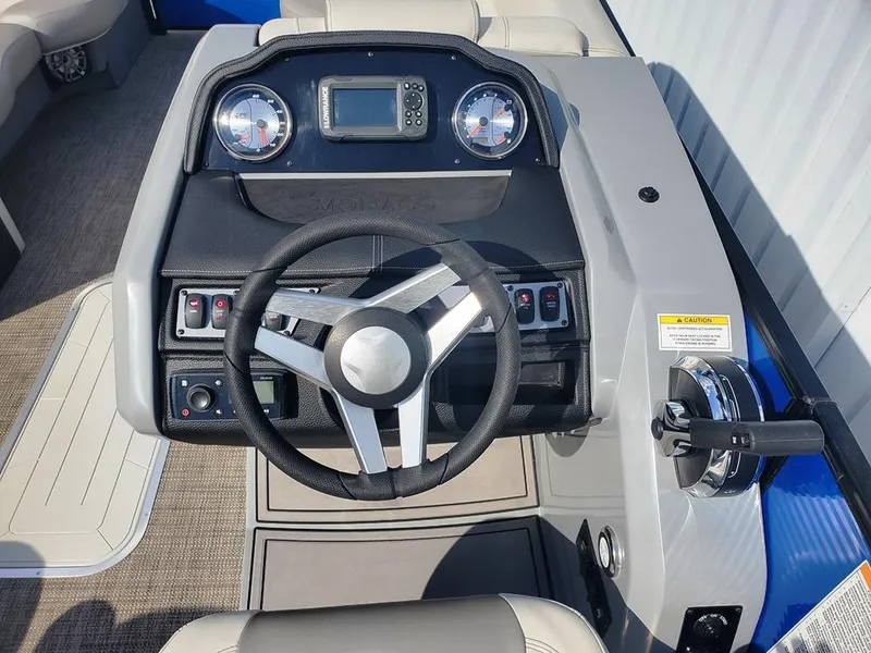 Slide: The Image of 2021 Godfrey Monaco 235RL boat dashboard with steering wheel and controls. - 12