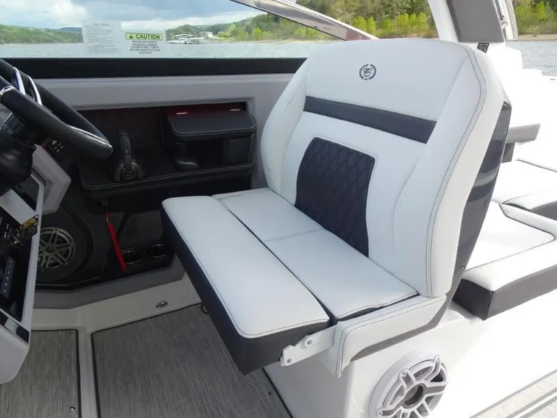 Slide: The Image of 2025 Cobalt R33 boat interior with white and black seating, steering wheel, and speaker. - 25