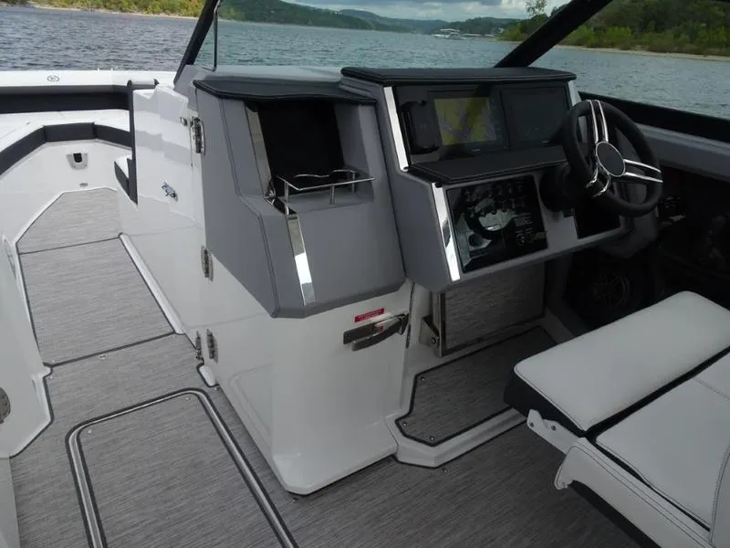 Slide: The Image of 2025 Cobalt R33 boat interior with modern dashboard and seating on a lake. - 28
