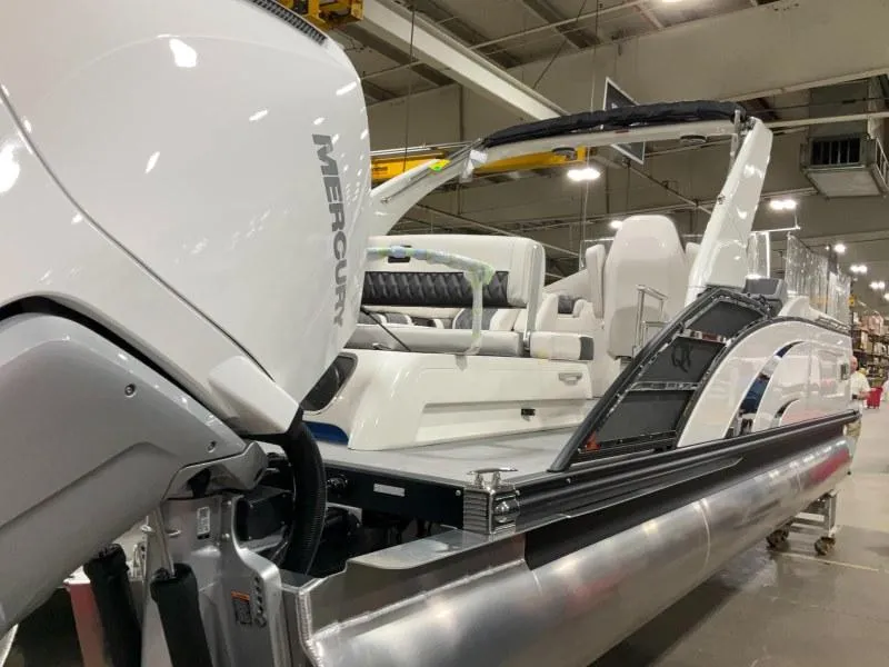 Slide: The Image of 2024 Bennington 27QXSBA-T2 pontoon boat with Mercury engine in a showroom. - 10