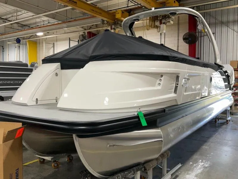 Slide: The Image of 2024 Bennington 27QXSBA-T2 pontoon boat in a warehouse setting. - 4