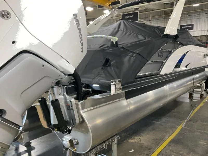 Slide: The Image of 2024 Bennington 27QXSBA-T2 pontoon boat with Mercury engine in a showroom. - 5