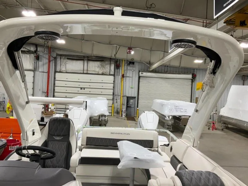 Slide: The Image of 2024 Bennington 27QXSBA-T2 boat interior in a warehouse setting. - 8