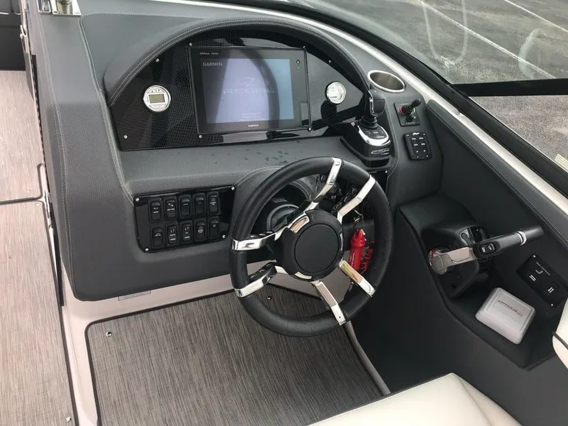 Slide: The Image of 2017 Regal 29 OBX boat dashboard with steering wheel and control panel. - 2