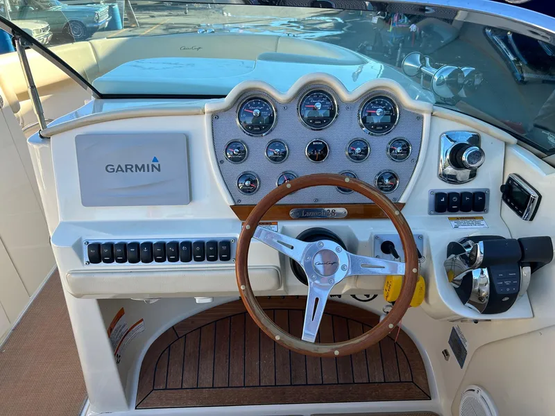 Slide: The Image of 2015 Chris-Craft Launch 28 dashboard with Garmin navigation and wooden steering wheel. - 11