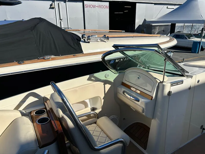 Slide: The Image of 2015 Chris-Craft Launch 28 boat interior with beige seating and wood accents. - 12