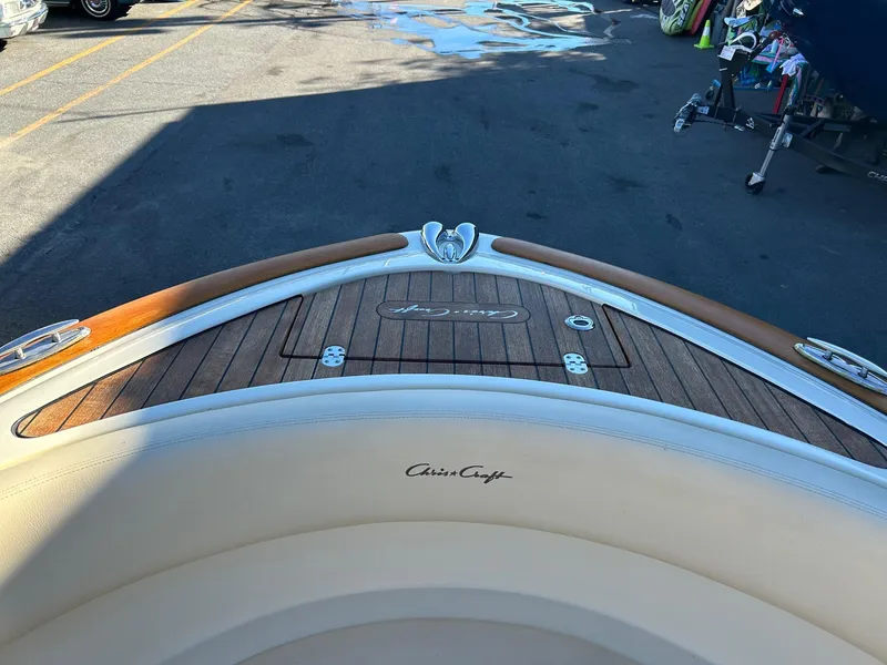 Slide: The Image of 2015 Chris-Craft Launch 28 boat with teak deck and logo, parked outdoors. - 16