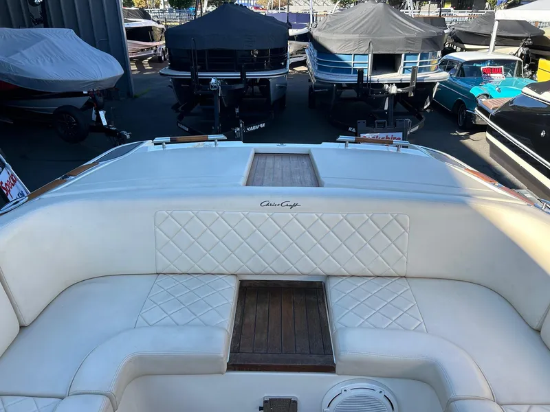 Slide: The Image of 2015 Chris-Craft Launch 28 boat interior with white quilted seating and wood accents. - 18