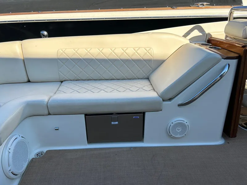 Slide: The Image of 2015 Chris-Craft Launch 28 boat interior with beige leather seating and built-in speakers. - 19
