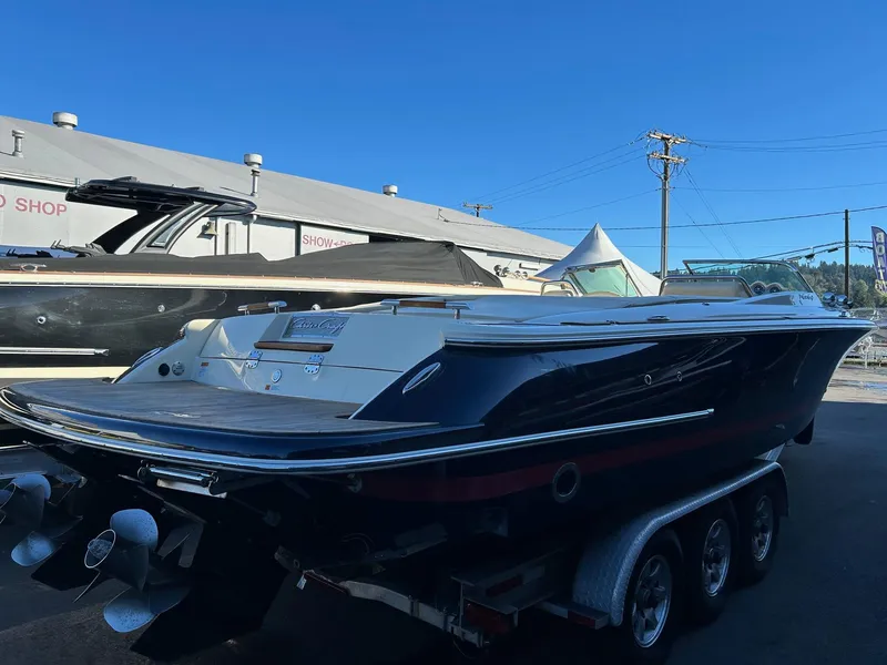 Slide: The Image of 2015 Chris-Craft Launch 28 boat on trailer, parked outdoors under clear blue sky. - 4