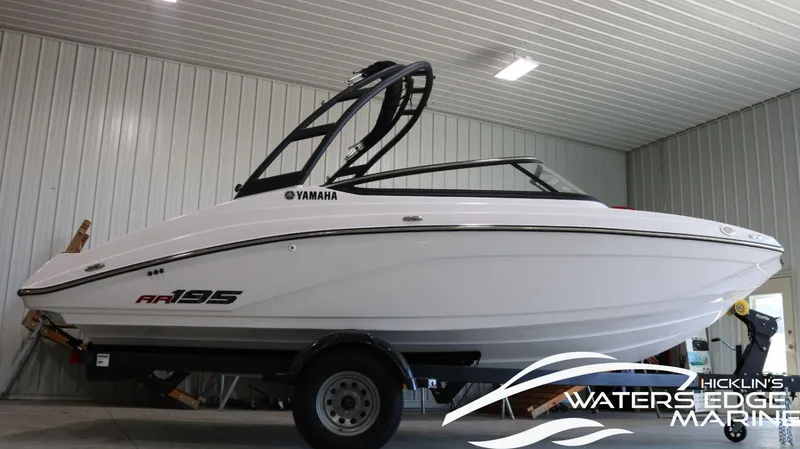 Slide: The Image of 2025 Yamaha AR195 boat in showroom, side view, on trailer. - 1