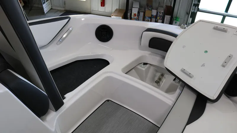 Slide: The Image of 2025 Yamaha Boats AR195 interior with open storage compartment and seating area. - 11