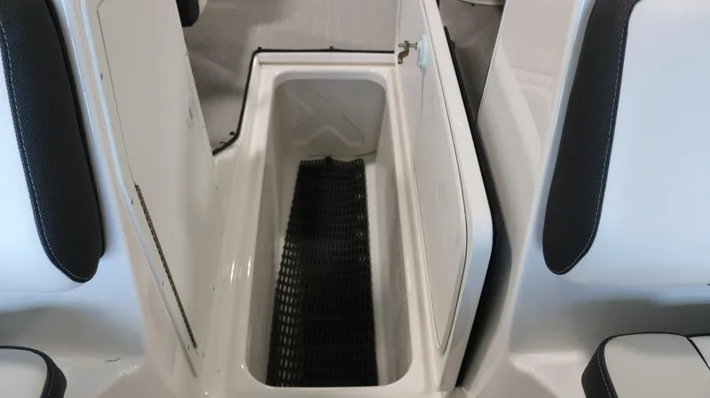 Slide: The Image of 2025 Yamaha AR195 boat storage compartment with open hatch and black mat. - 14