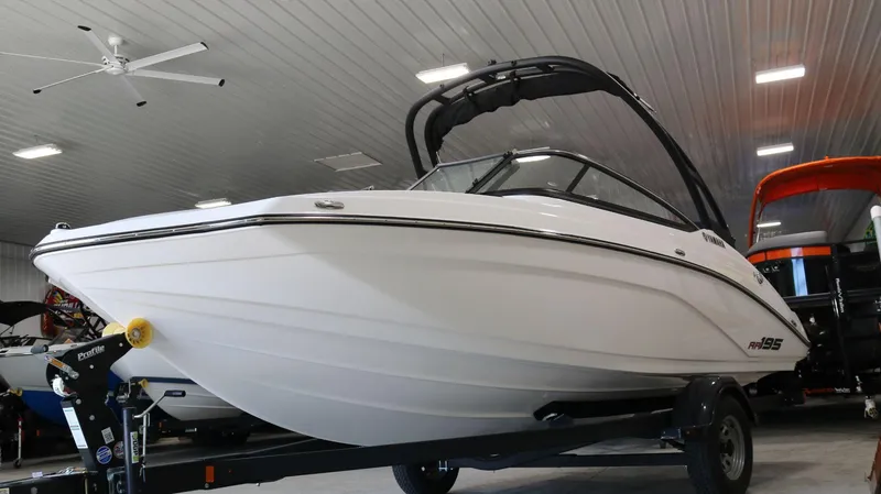 Slide: The Image of 2025 Yamaha AR195 boat in showroom, sleek design, on trailer. - 4