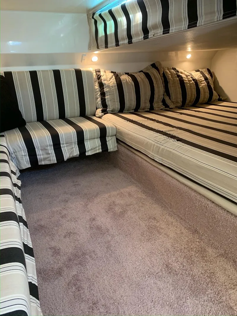 Slide: The Image of Interior cabin of 1996 Wellcraft 45 Excalibur with striped upholstery and cozy lighting. - 17
