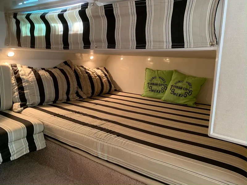 Slide: The Image of Interior cabin of 1996 Wellcraft 45 Excalibur with striped bedding and cushions. - 18
