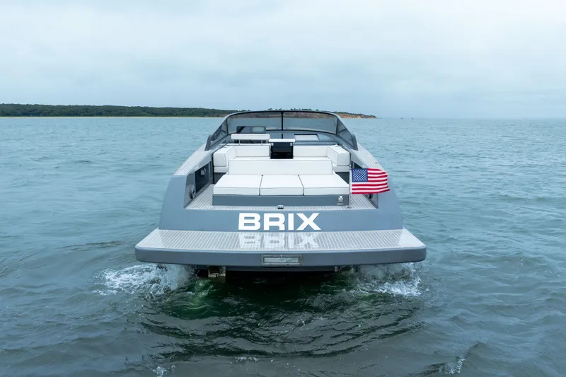 Slide: The Image of 2023 VanDutch 48 yacht on water, rear view with American flag. - 10