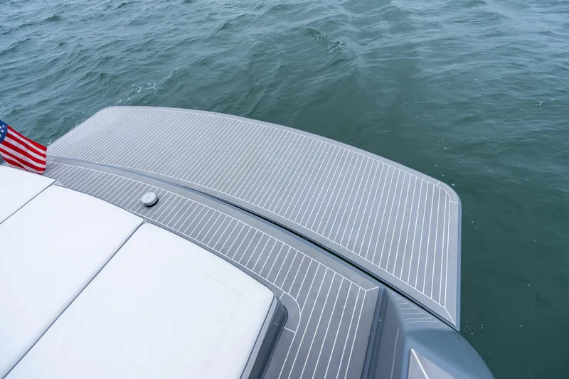 Slide: The Image of VanDutch 48 yacht deck with American flag, 2023 model, on calm water. - 11