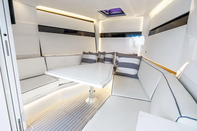 Slide: The Image of Luxurious interior of 2023 VanDutch 48 yacht with sleek white seating and striped cushions. - 24