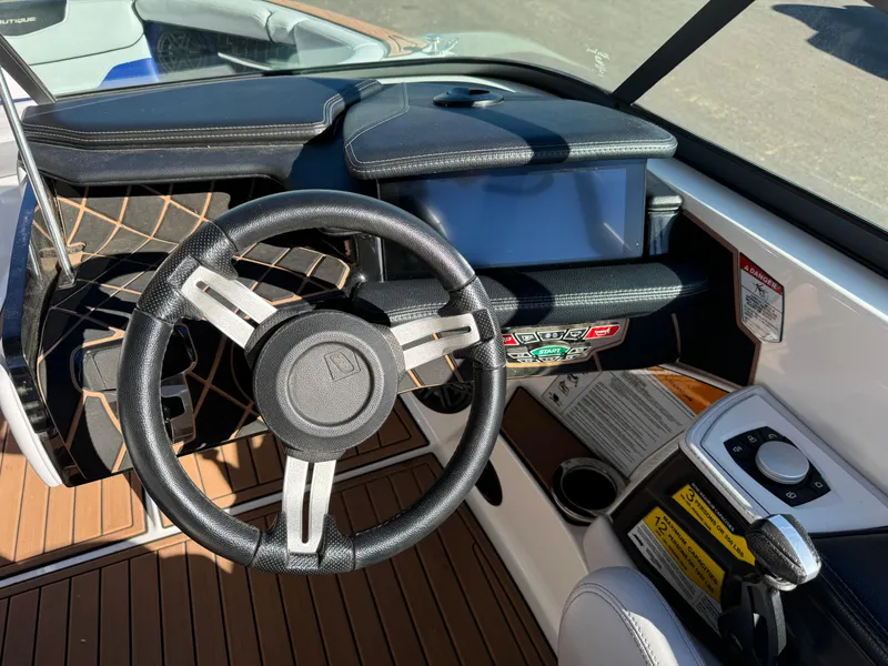 Slide: The Image of 2017 Nautique GS20 boat dashboard with steering wheel and control panel. - 10