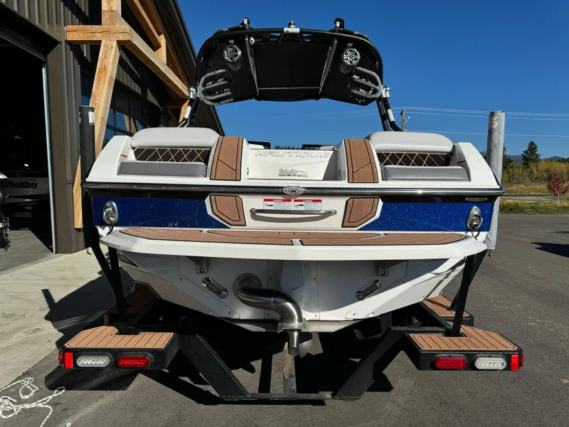Slide: The Image of 2017 Nautique GS20 boat rear view, parked outdoors, showcasing deck and speakers. - 3