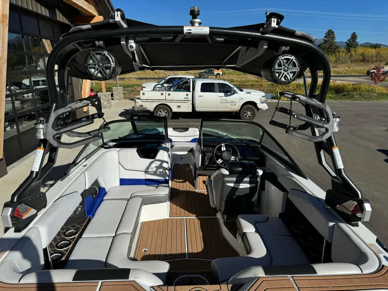 Slide: The Image of 2017 Nautique GS20 boat interior with seating, speakers, and steering wheel, parked outdoors. - 6