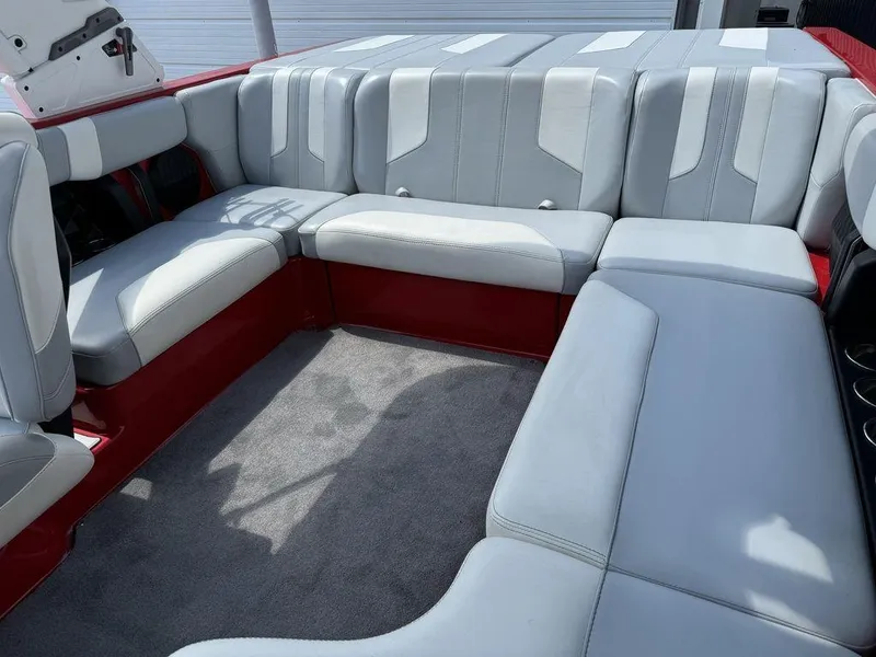 Slide: The Image of 2022 Malibu 21 LX boat interior with gray and red seating. - 12