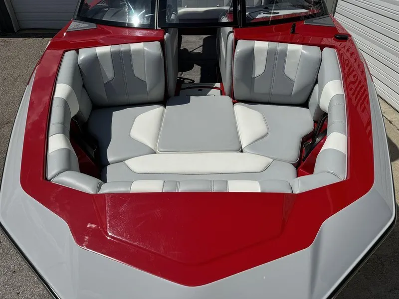 Slide: The Image of 2022 Malibu 21 LX boat interior with red and gray seating. - 2