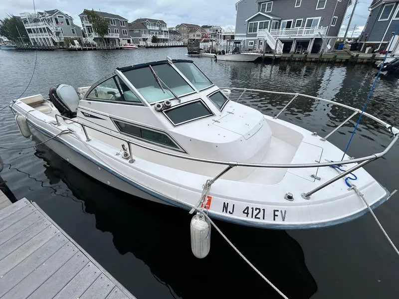 The Image of 1993 Grady-White 24 Explorer boat docked in a marina, surrounded by waterfront homes. - 0
