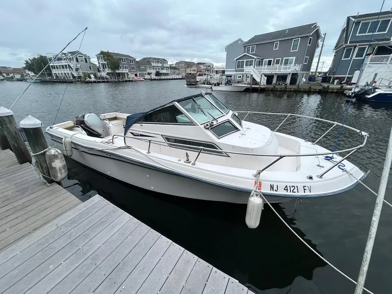 Slide: The Image of 1993 Grady-White 24 Explorer boat docked in a marina, surrounded by waterfront homes. - 1
