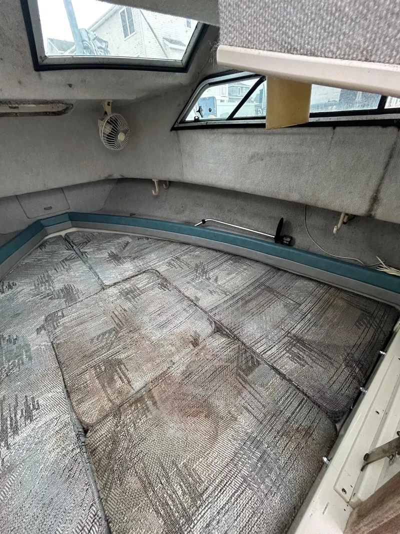 Slide: The Image of 1993 Grady-White 24 Explorer cabin interior with cushioned seating and windows. - 12