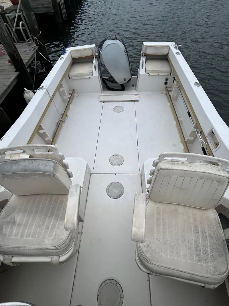 Slide: The Image of 1993 Grady-White 24 Explorer boat interior with seating, docked by the water. - 18