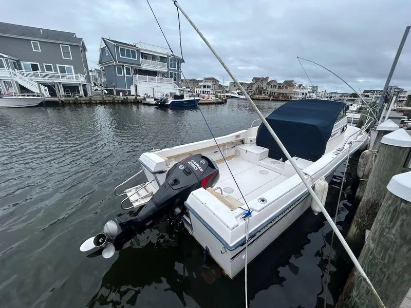 Slide: The Image of 1993 Grady-White 24 Explorer boat docked in a marina, featuring an outboard motor. - 2