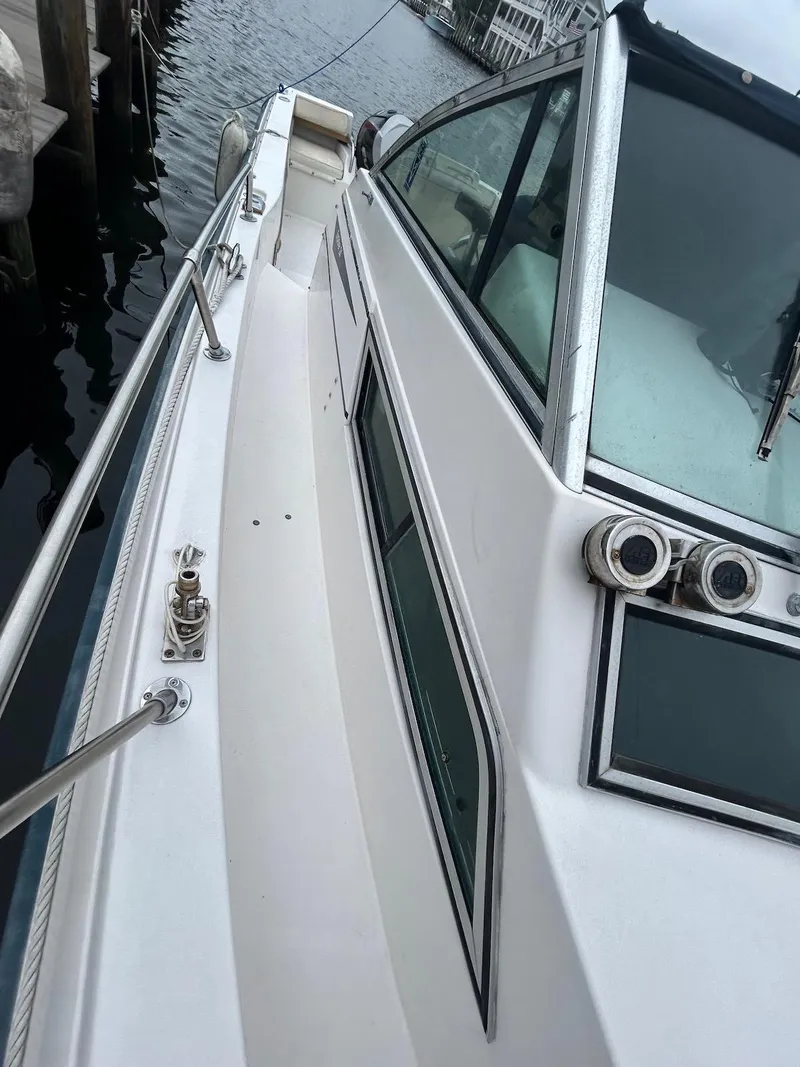 Slide: The Image of 1993 Grady-White 24 Explorer boat docked, showcasing sleek design and windows. - 23