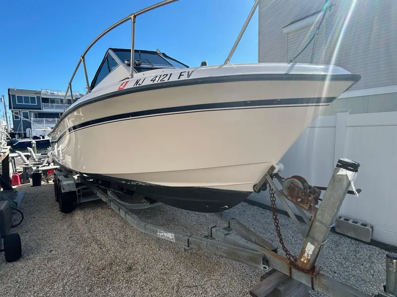 Slide: The Image of 1993 Grady-White 24 Explorer boat on trailer, parked outdoors under clear blue sky. - 29