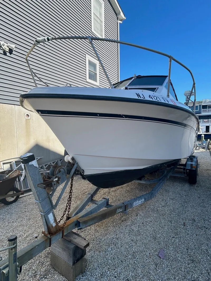Slide: The Image of 1993 Grady-White 24 Explorer boat on trailer, parked beside a building. - 30