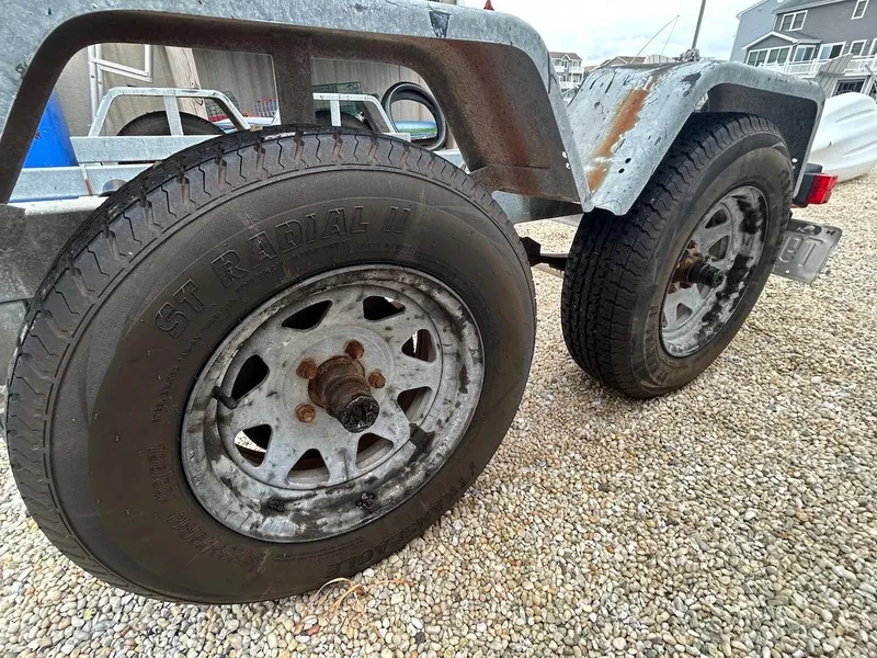 Slide: The Image of Trailer wheels for 1993 Grady-White 24 Explorer boat on gravel surface. - 40